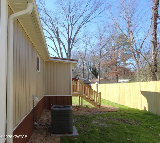 a view of backyard with wooden fence