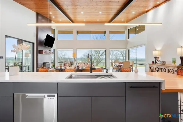 a dining hall with stainless steel appliances kitchen island granite countertop a table and chairs