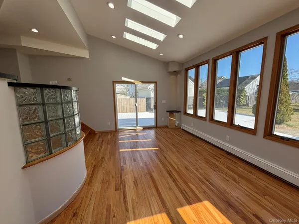 a view of hallway with a large window and wooden floor