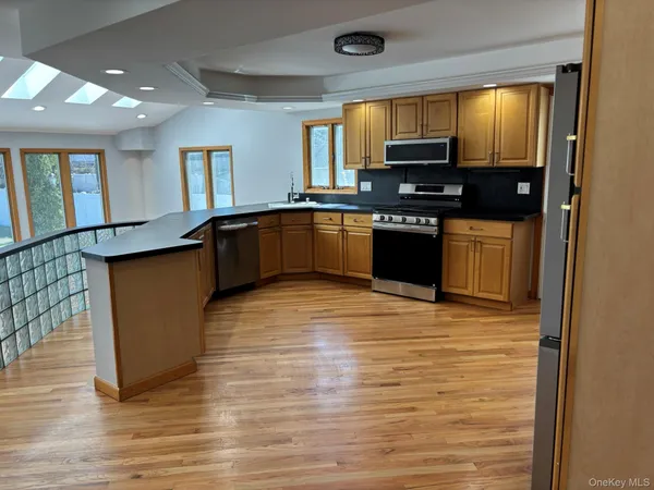 a kitchen with stainless steel appliances granite countertop a stove a sink and a microwave