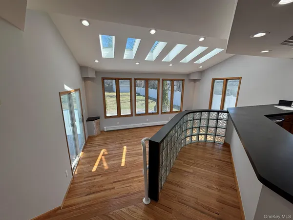 a view of a hallway with wooden floor and staircase