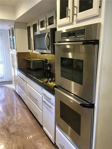 a kitchen with granite countertop a stove and a microwave