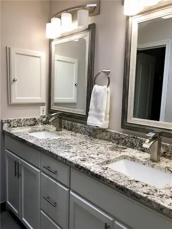 a bathroom with a granite countertop sink and a mirror