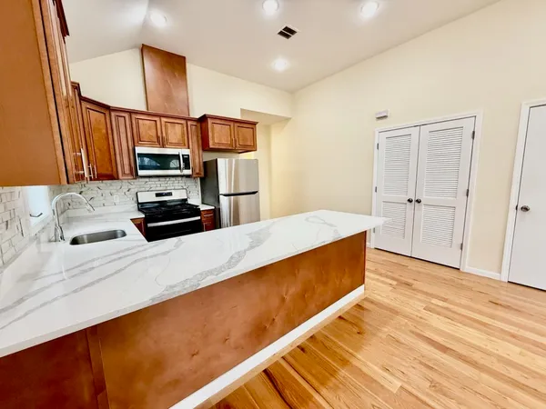 a kitchen with stainless steel appliances a refrigerator sink and microwave