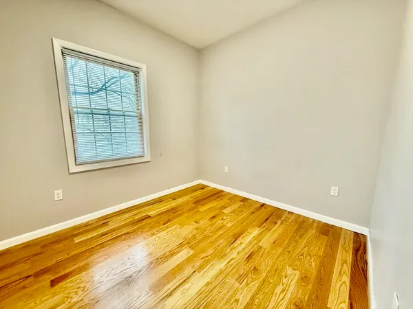 a view of a room with wooden floor and a window