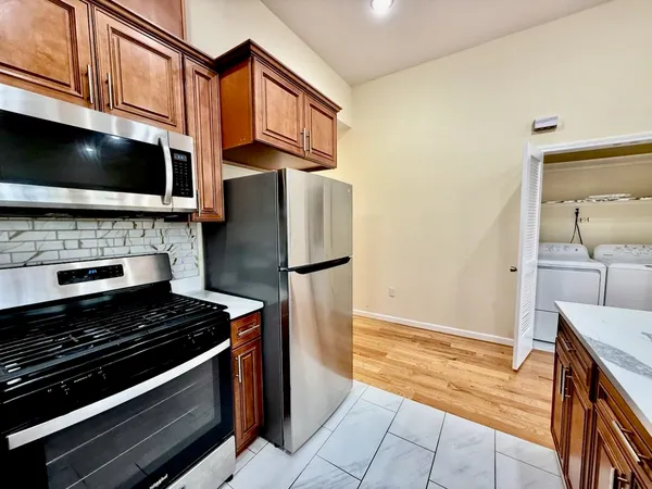 a kitchen with stainless steel appliances a stove a microwave and a sink