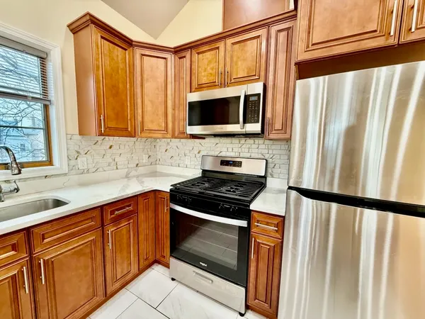 a kitchen with stainless steel appliances granite countertop a stove microwave and sink
