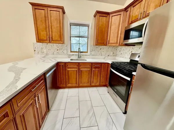 a kitchen with stainless steel appliances granite countertop a sink stove and microwave