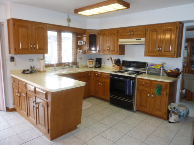1377 Lilac Lane Addison, IL 60101 - Photo 3 of 21 a kitchen with a sink stove top oven and cabinets