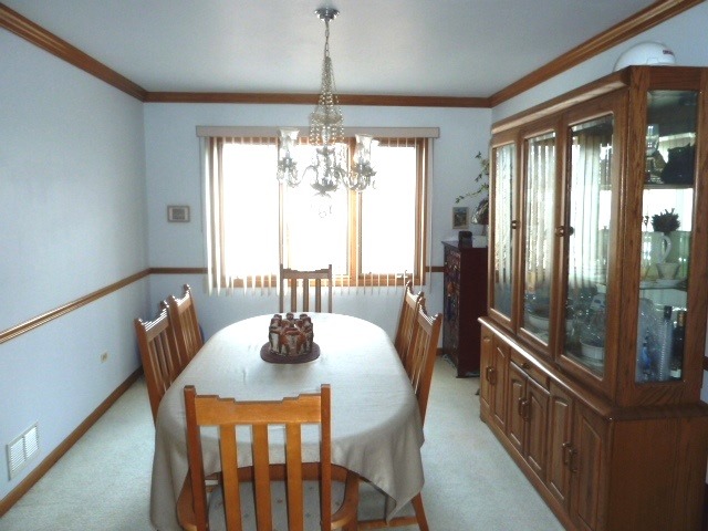 1377 Lilac Lane Addison, IL 60101 - Photo 6 of 21 a dining room with furniture a chandelier and wooden floor