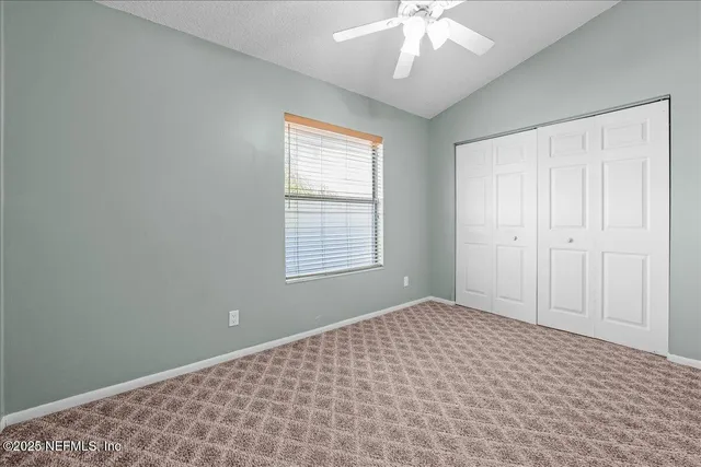 an empty room with a chandelier fan