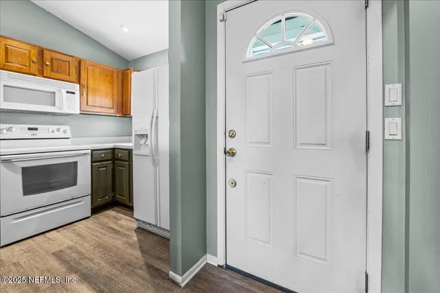 a view of a kitchen with a stove wooden cabinets and a window