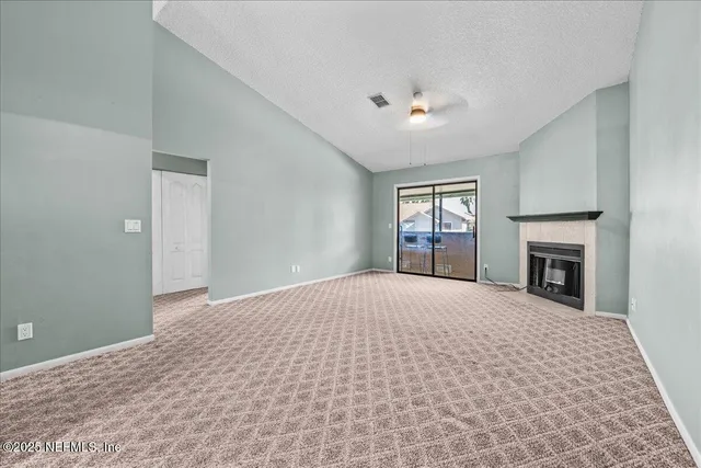 a big room with windows and fireplace