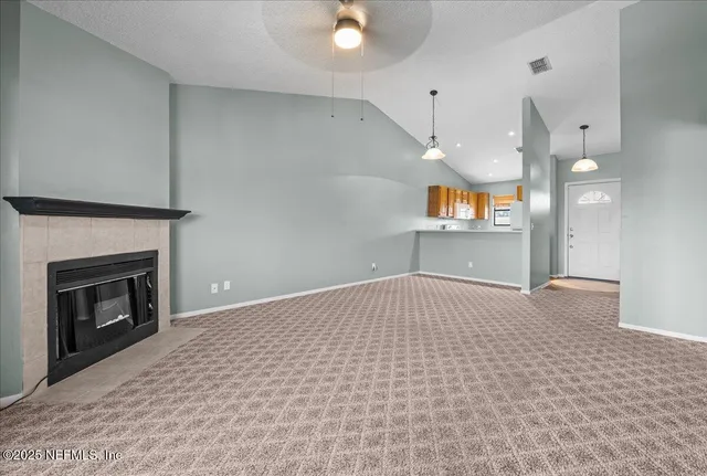 a view of empty room with a fireplace and fan