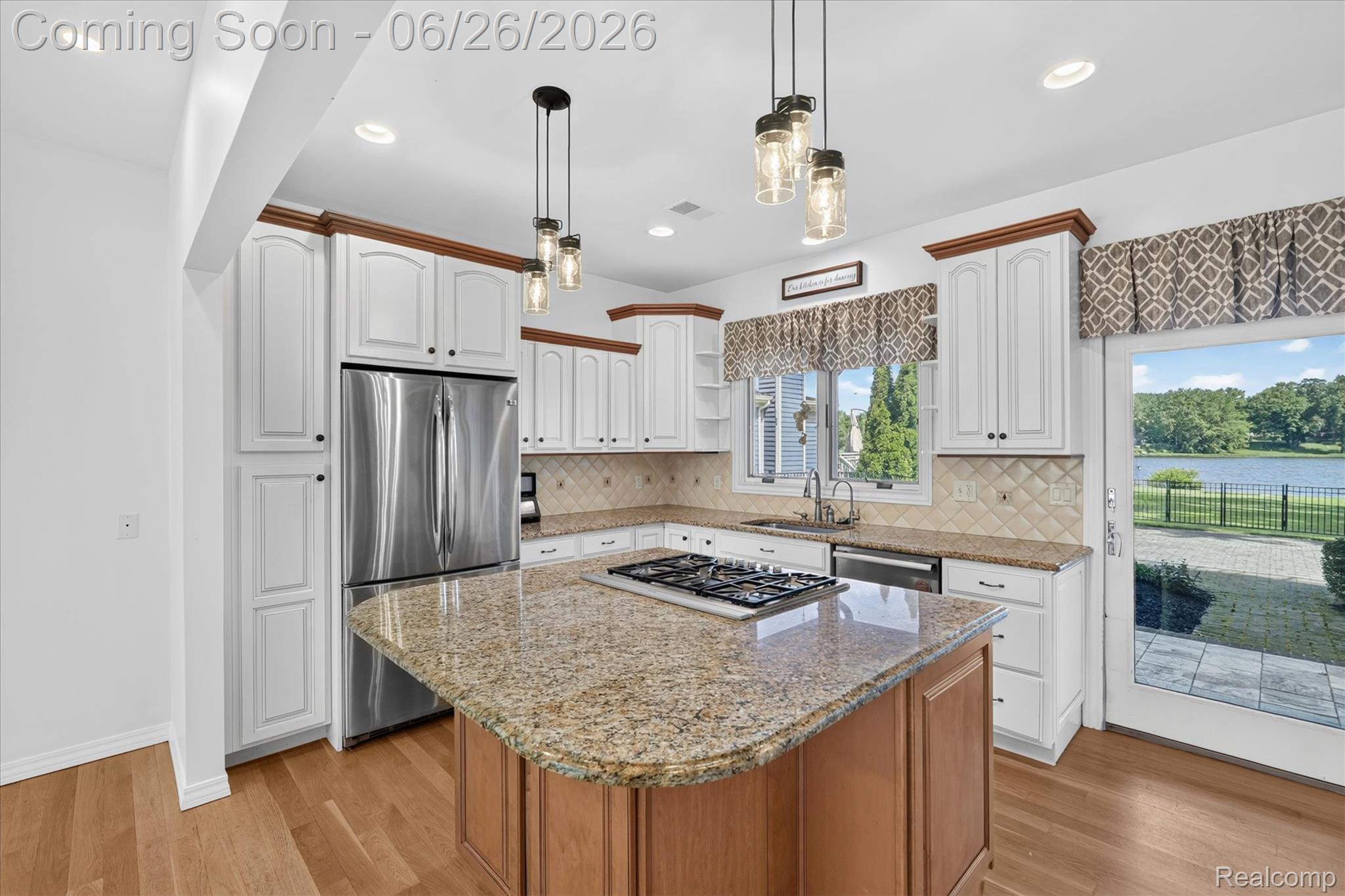 3478 Lexington Road Waterford, MI 48328 - Photo 7 of 52 Kitchen featuring white cabinetry with rich wood crown molding, a central island with granite countertops, stainless steel appliances, and a tile backsplash