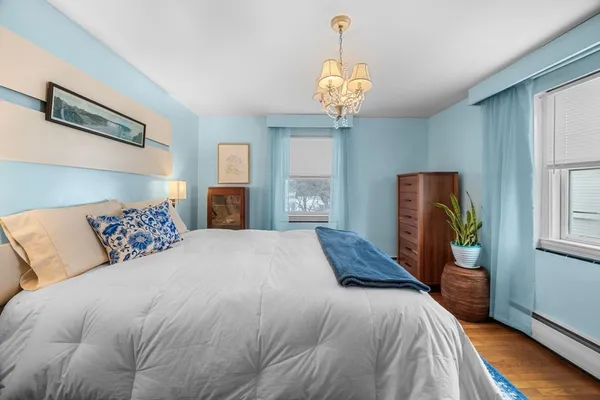 a bedroom with a large bed and a chandelier