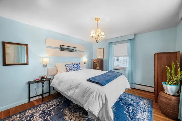 a bedroom with bed and wooden floor