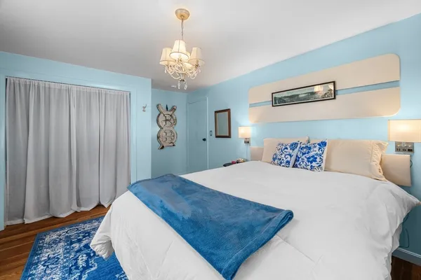 a bedroom with a large bed and a chandelier