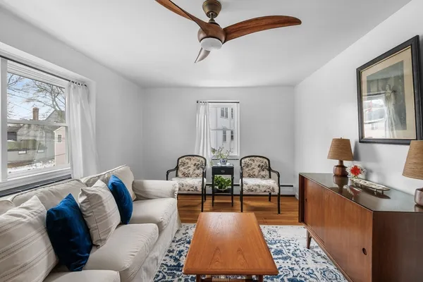 a living room with furniture a rug and a window