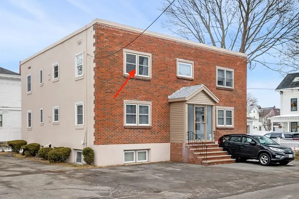 a car parked in front of a brick house