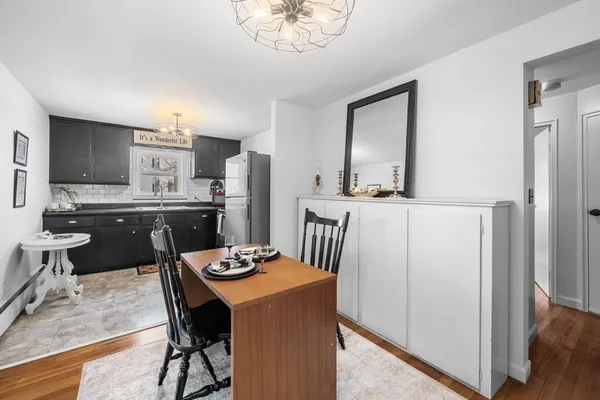 a kitchen with stainless steel appliances kitchen island granite countertop a refrigerator a stove a sink a dining table and chairs