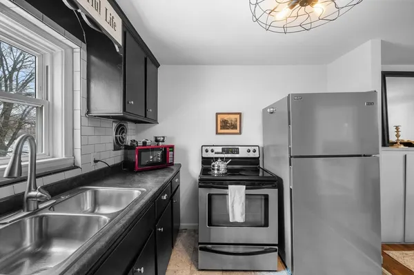 a kitchen with a refrigerator sink and white cabinets