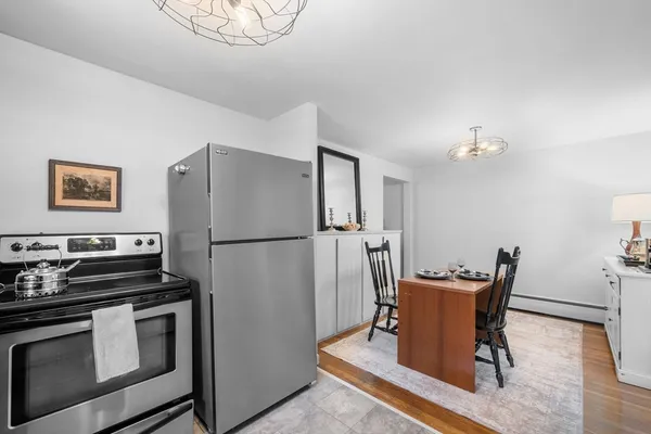 a kitchen with stainless steel appliances wooden floor and a refrigerator