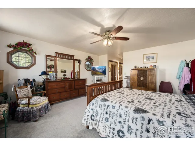 a living room with a bed furniture a mirror and a flat tv screen