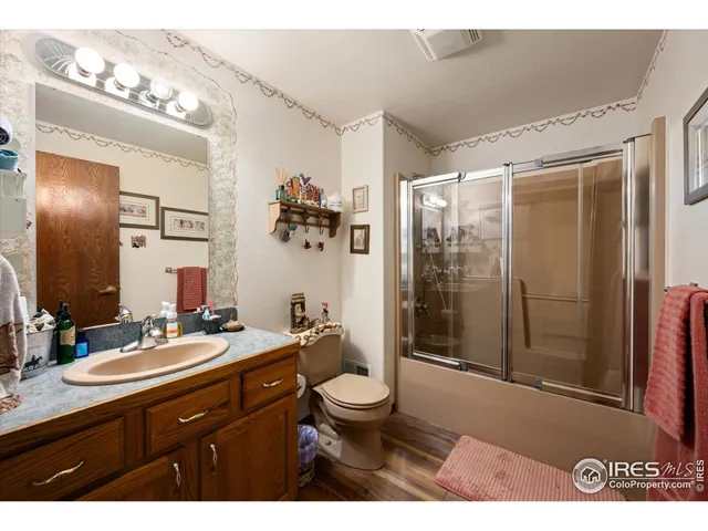 a bathroom with a sink a toilet a mirror and shower