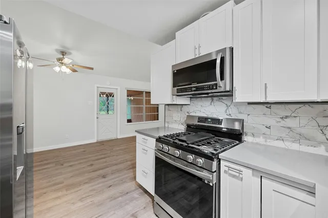 a kitchen with stainless steel appliances a stove a microwave and cabinets