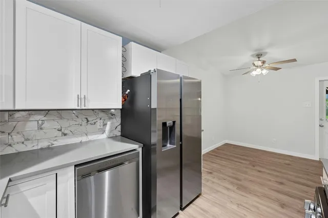 a kitchen with stainless steel appliances granite countertop a refrigerator and a sink