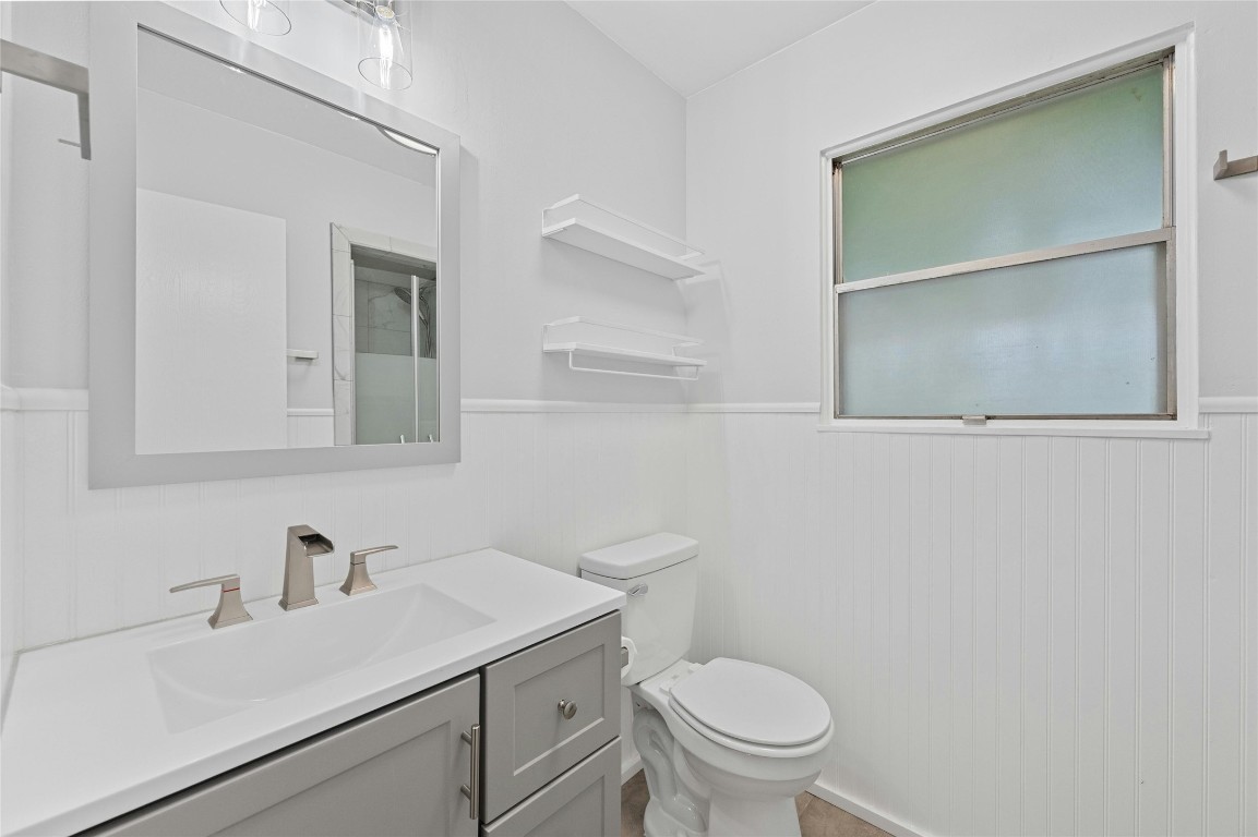 4906 Sylvandale Drive Austin, TX 78745 - Photo 15 of 28 a bathroom with a sink a toilet and a mirror