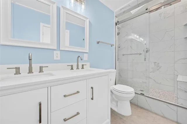 a bathroom with a sink a toilet and shower