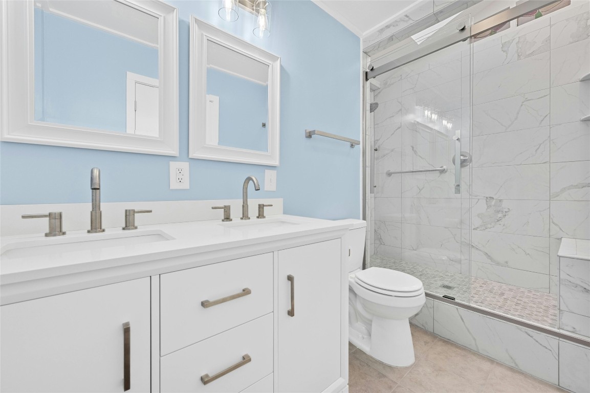 4906 Sylvandale Drive Austin, TX 78745 - Photo 21 of 28 a bathroom with a sink a toilet and shower