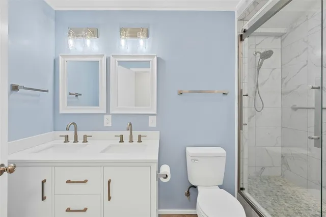 a bathroom with a sink a toilet and shower