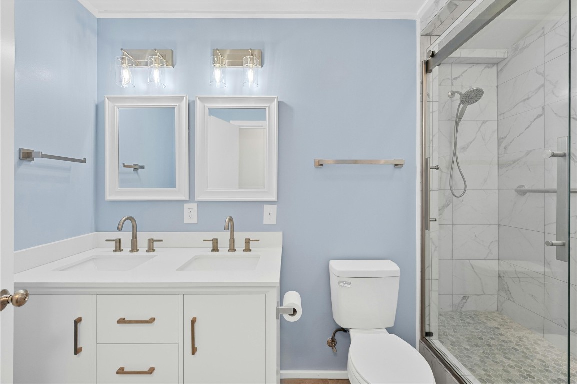 4906 Sylvandale Drive Austin, TX 78745 - Photo 22 of 28 a bathroom with a sink a toilet and shower