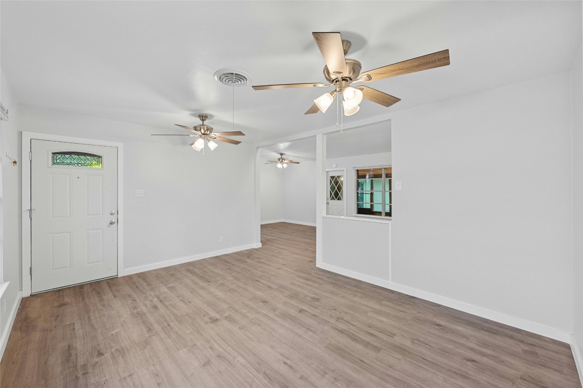 4906 Sylvandale Drive Austin, TX 78745 - Photo 5 of 28 an empty room with wooden floor chandelier fan and closet area
