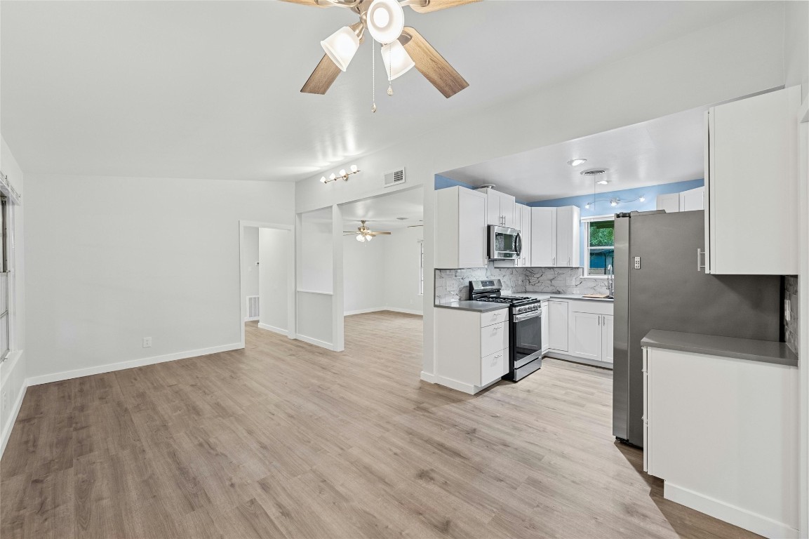 4906 Sylvandale Drive Austin, TX 78745 - Photo 8 of 28 a large kitchen with cabinets wooden floor and stainless steel appliances