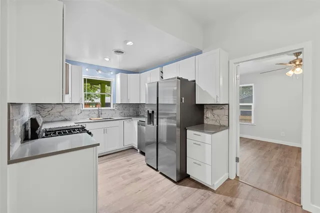 a kitchen with white cabinets and stainless steel appliances
