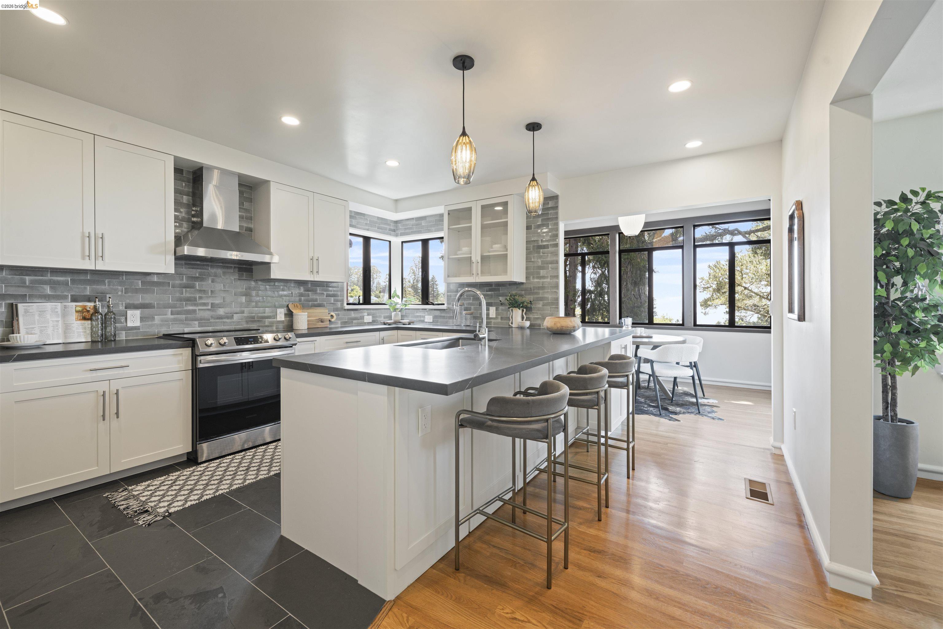 1170 Sterling Avenue Berkeley, CA 94708 - Photo 11 of 52 Kitchen featuring dark countertops, electric range, a breakfast bar, backsplash, and white cabinetry