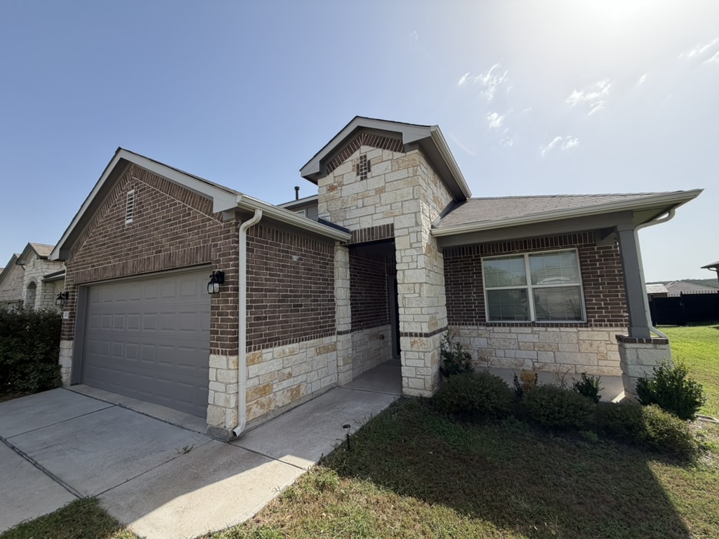 10708 Gonzales Ranger Pass Austin, TX 78754 - Photo 7 of 40 A striking facade with brick and stone accents creates inviting curb appeal.