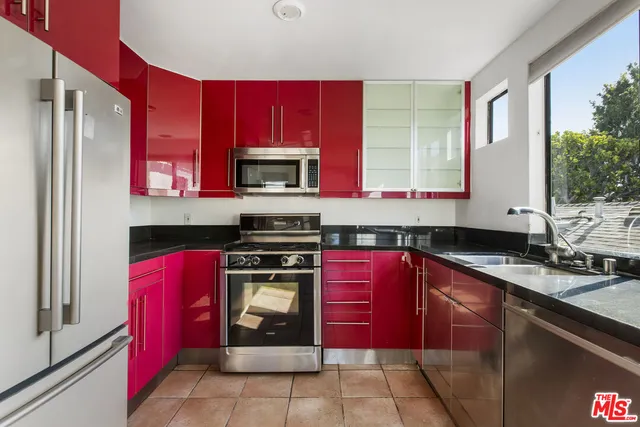 a kitchen with stainless steel appliances a stove sink and microwave