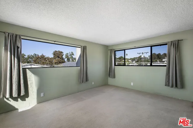 an empty room with windows and closet