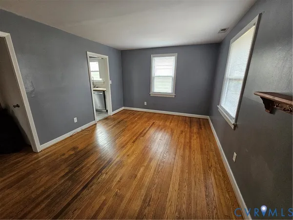 wooden floor in an empty room with a window