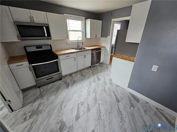 a kitchen with a sink a window and stainless steel appliances