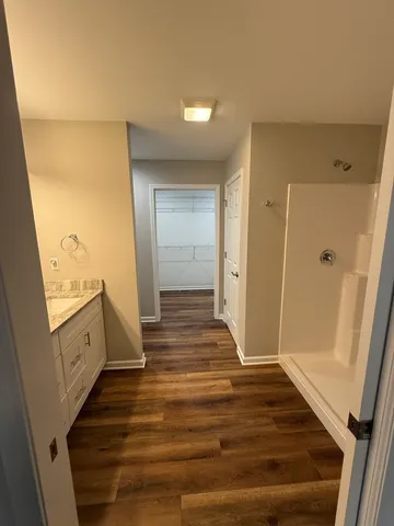 a view of a hallway with wooden floor and staircase