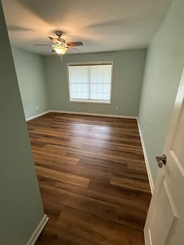 a view of empty room with window and wooden floor