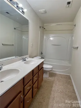 a bathroom with a double vanity sink toilet and shower