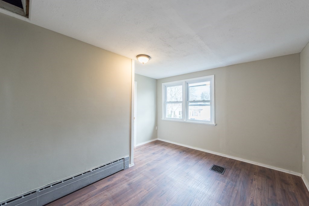 84 Lamont Street Springfield, MA 01119 - Photo 18 of 21 an empty room with wooden floor and windows