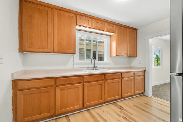 2862 Fowler Avenue Ogden, UT 84403 - Photo 15 of 23 Kitchen featuring light wood cabinetry, light-toned countertops, a stainless steel sink, and wood-finish flooring